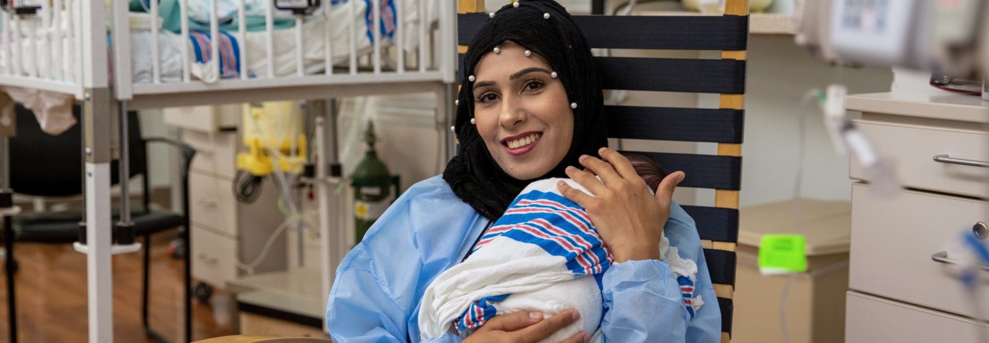 Mother holds newborn in hospital