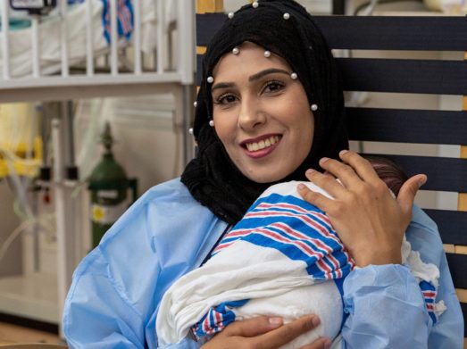 Mother holds newborn in hospital