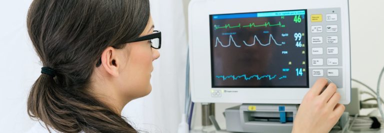 Healthcare worker sets up patient monitor machine