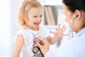 Child happily waving at doctor