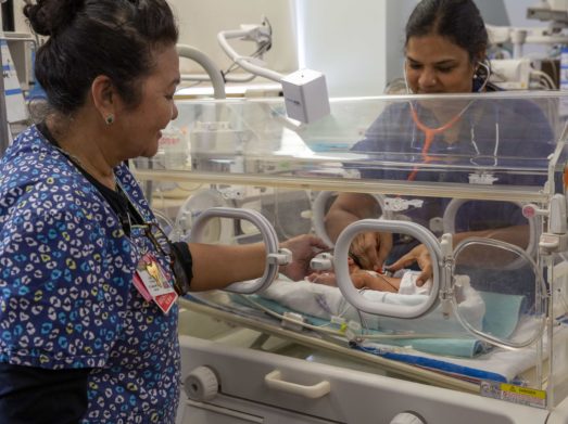 Doctor and nurse provide care to baby in NICU