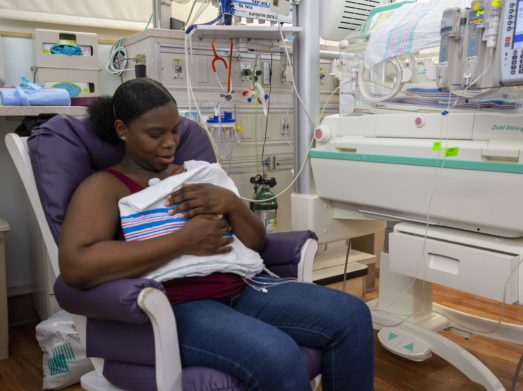 Woman cradles newborn in hospital