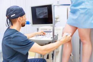 A medical technician scans a woman's leg veins
