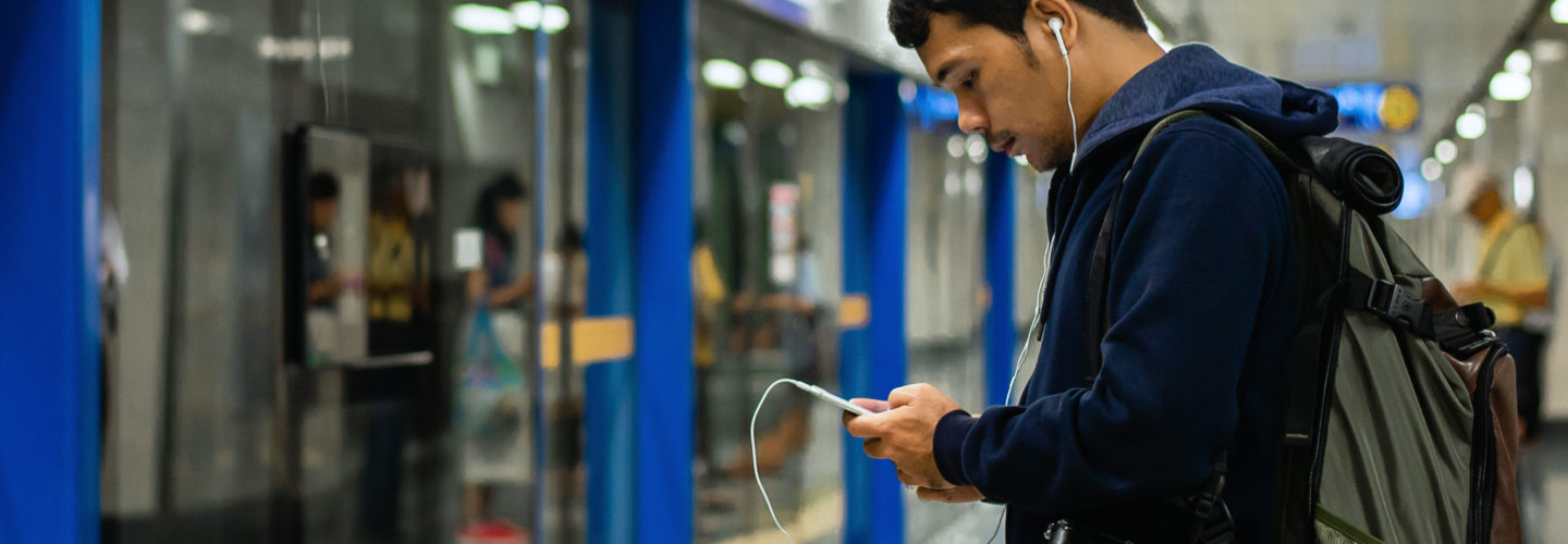 Young man uses smartphone on public transit
