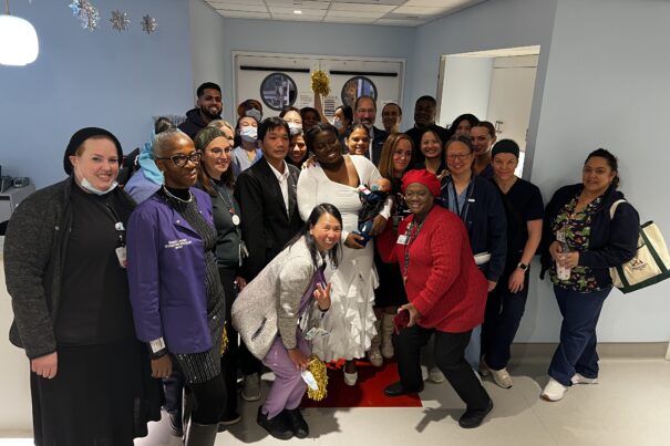 Staff and doctors posing with Elijah and his parents, all smiling