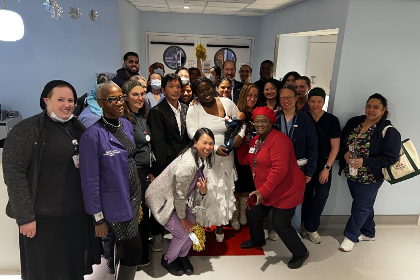 Staff and doctors posing with Elijah and his parents, all smiling