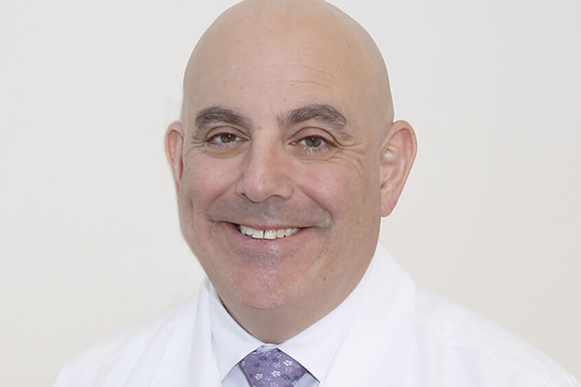 Dr. John Marshall smiling and wearing a white coat