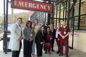 Emergency medicine team posing together outside of the emergency department entrance
